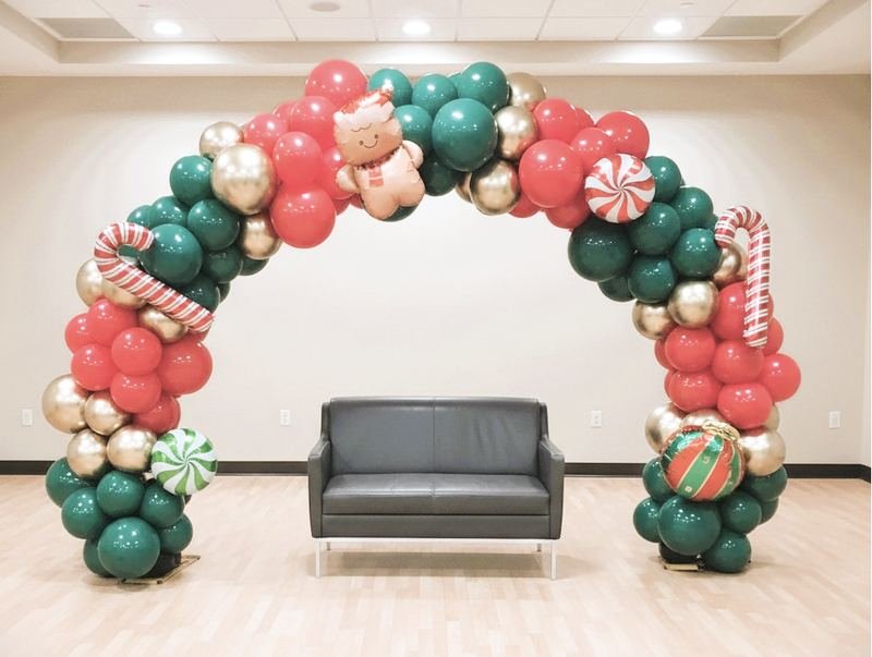 Full Christmas balloon arch in green, red and gold with candy cane and gingerbread balloons